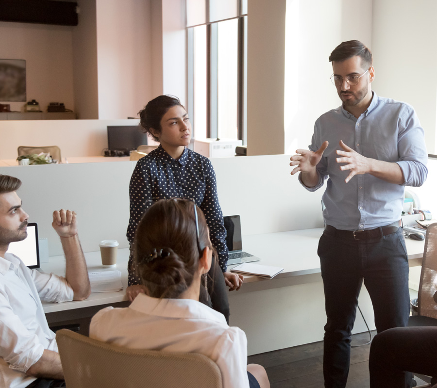 Serious team leader talk to diverse business people at meeting